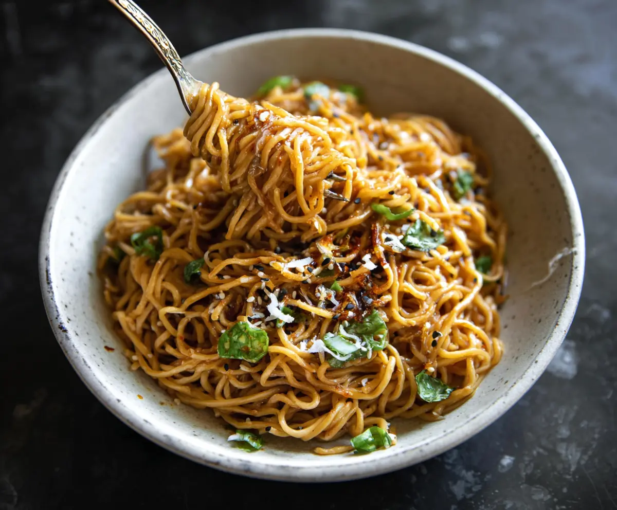 Savory Asian Garlic Noodles garnished with green onions on a white plate