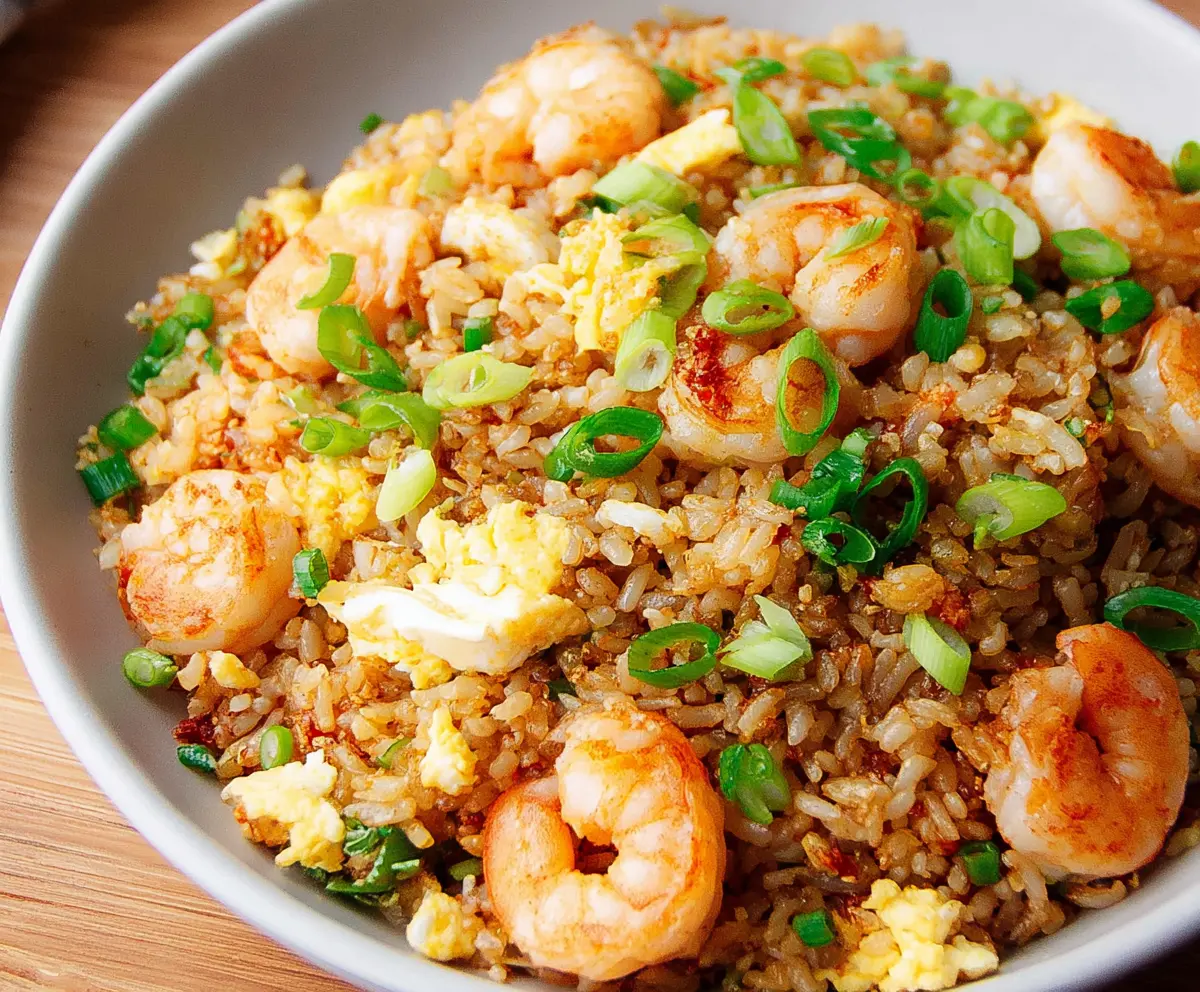 Delicious shrimp garlic fried rice served on a plate, garnished with fresh herbs.