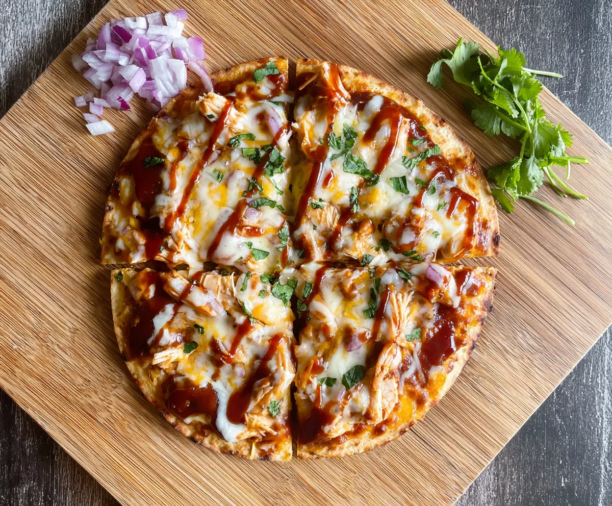 Delicious BBQ Chicken Tortilla Pizza topped with melted cheese and fresh herbs.