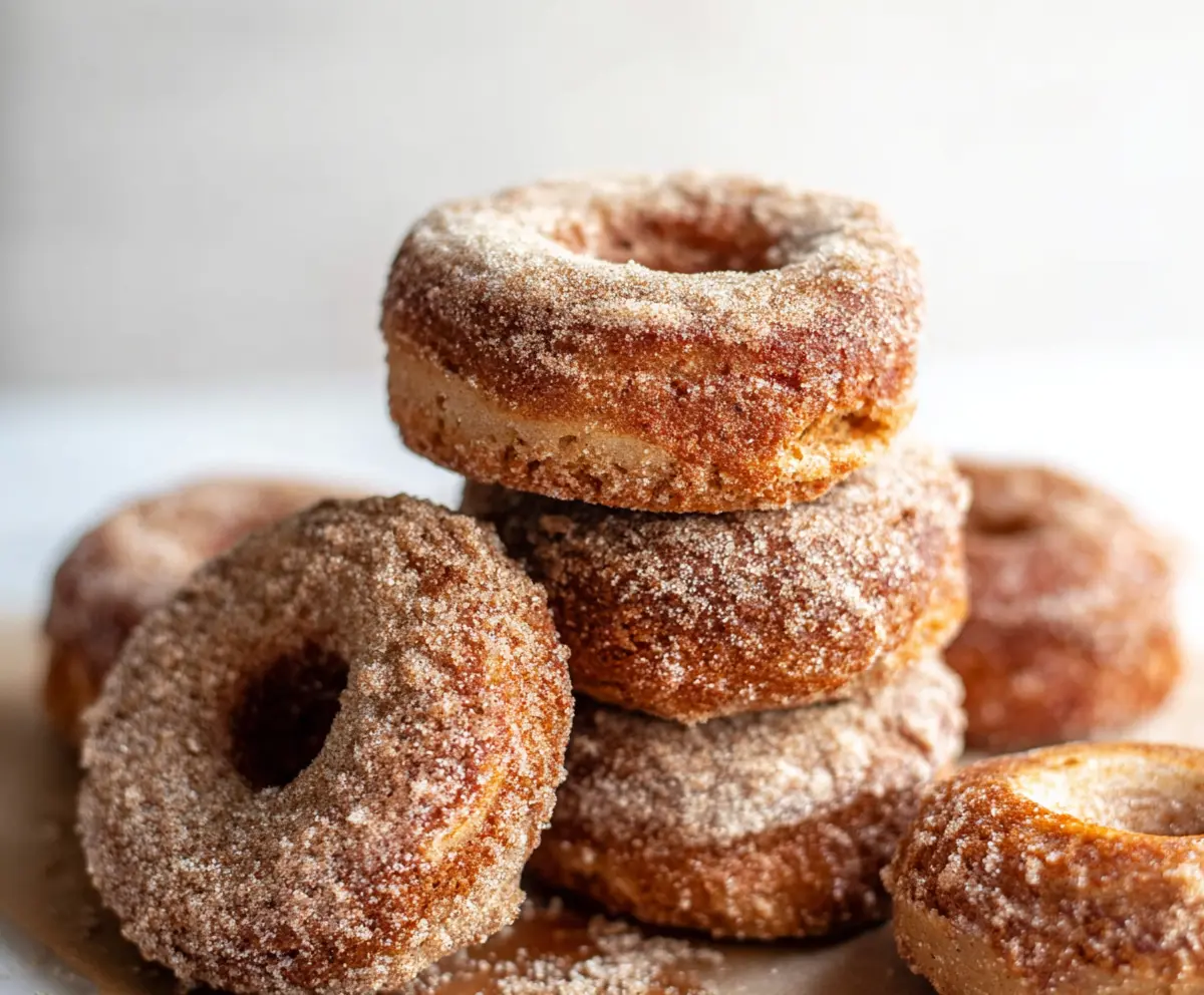 Fresh sourdough discard apple cider donuts bread served on a rustic plate with cinnamon sugar topping.