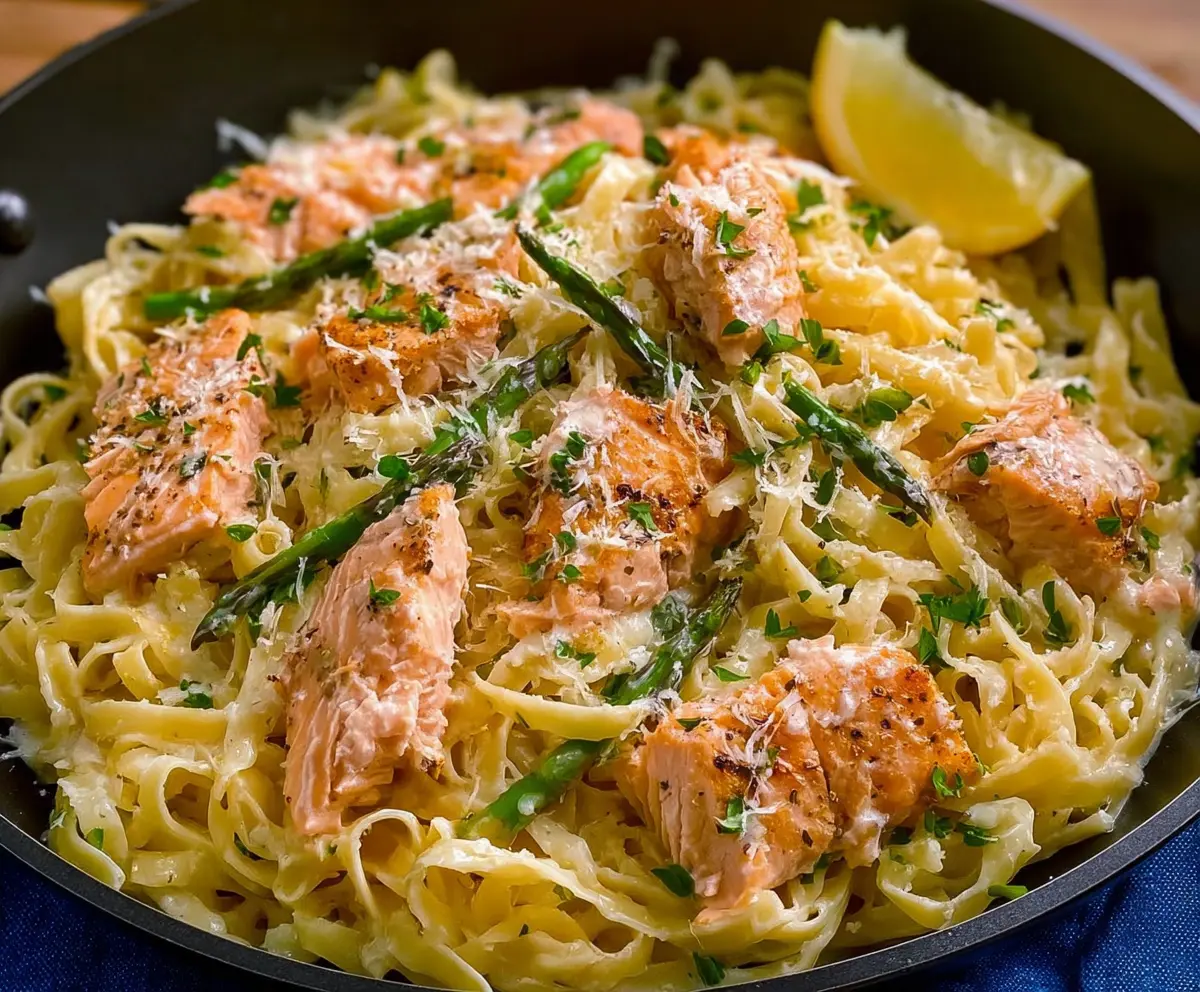 Delicious Lemon Butter Salmon Pasta with fresh herbs and tender salmon slices on a plate.